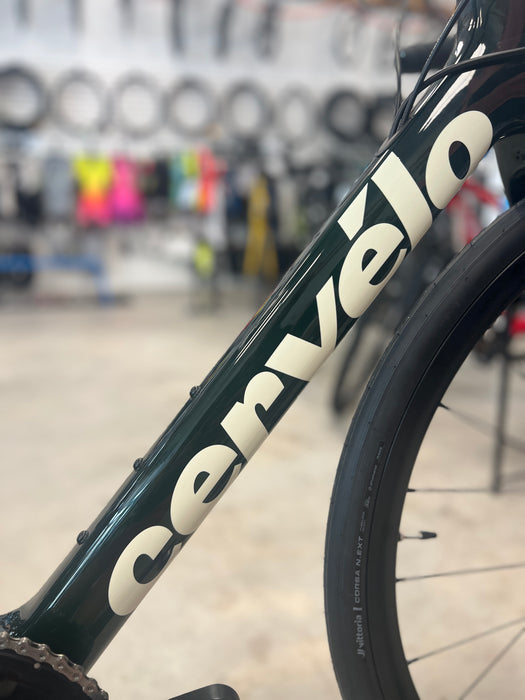 Close-up of a bicycle frame with 'Cervélo' branding in a bike shop setting.